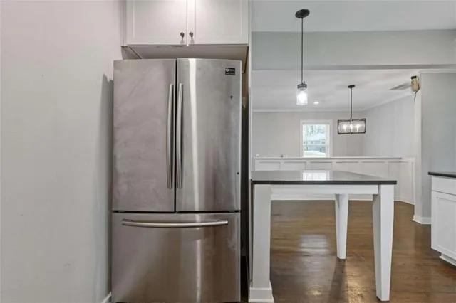 a kitchen with stainless steel appliances a refrigerator and a chandelier