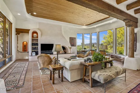 a living room with furniture fireplace and a large window