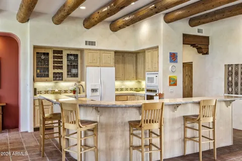 a kitchen with stainless steel appliances kitchen island granite countertop a table and chairs in it