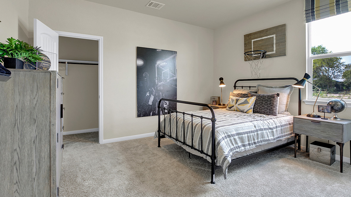 121 Little Walnut Cove Kyle, TX 78640 - Photo 22 of 31 a bed sitting in a bedroom next to a window and a chair