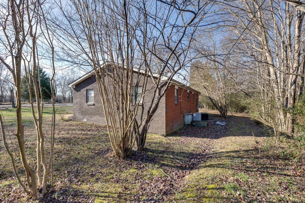 104 Shubert Road Hohenwald, TN 38462 - Photo 14 of 14 BACK YARD WITH TALL MATURED TREES AND CENTRAL HEAT AND AIR UNIT