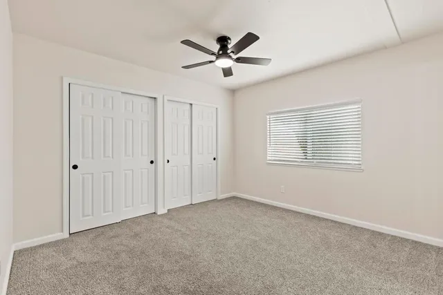 a view of an empty room with a ceiling fan