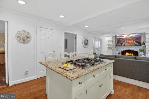 a kitchen with stainless steel appliances granite countertop a sink and cabinets with wooden floor