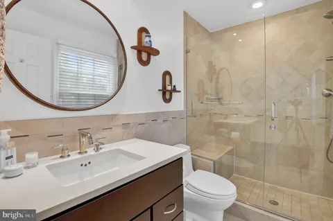 a bathroom with a granite countertop toilet sink and mirror
