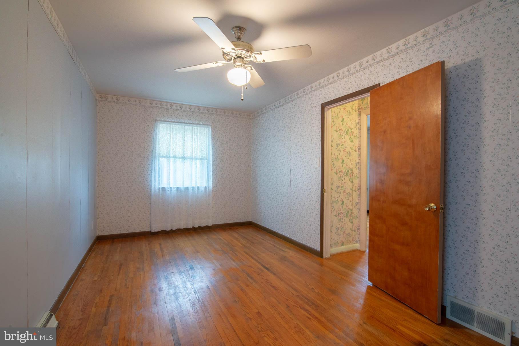 5061 Rippling Run Road Red Lion, PA 17356 - Photo 15 of 44 an empty room with wooden floor fan and windows