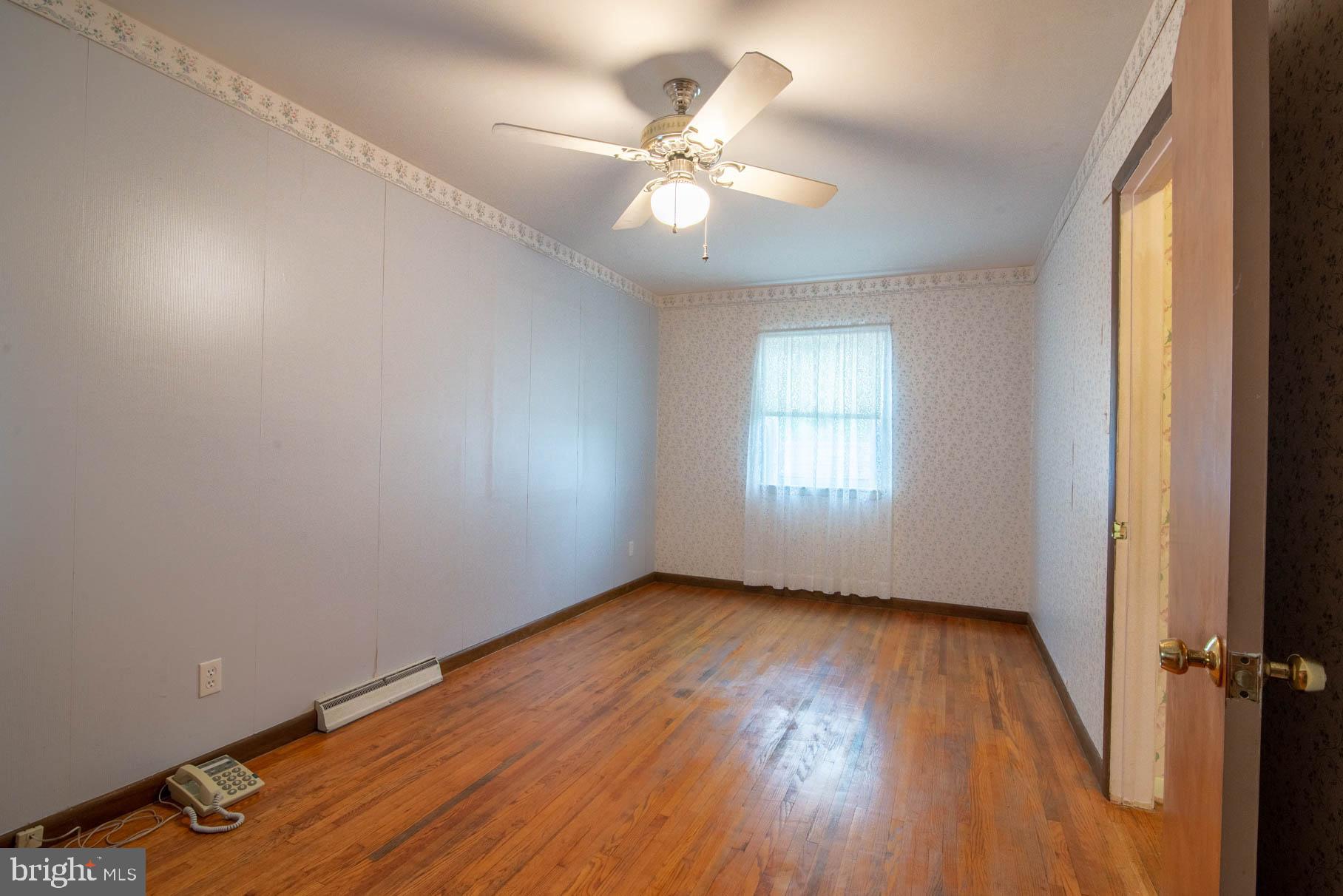 5061 Rippling Run Road Red Lion, PA 17356 - Photo 16 of 44 an empty room with wooden floor fan and windows