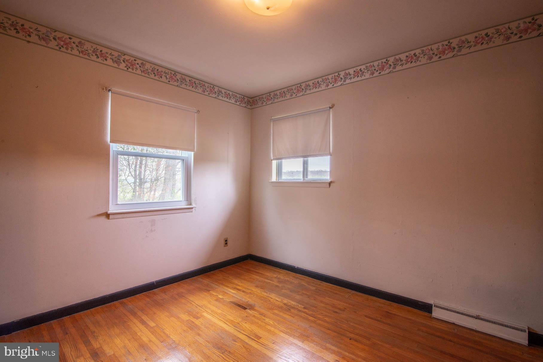 5061 Rippling Run Road Red Lion, PA 17356 - Photo 21 of 44 a view of an empty room with wooden floor and a window