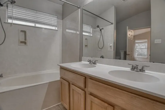 a bathroom with a granite countertop sink a shower and a mirror