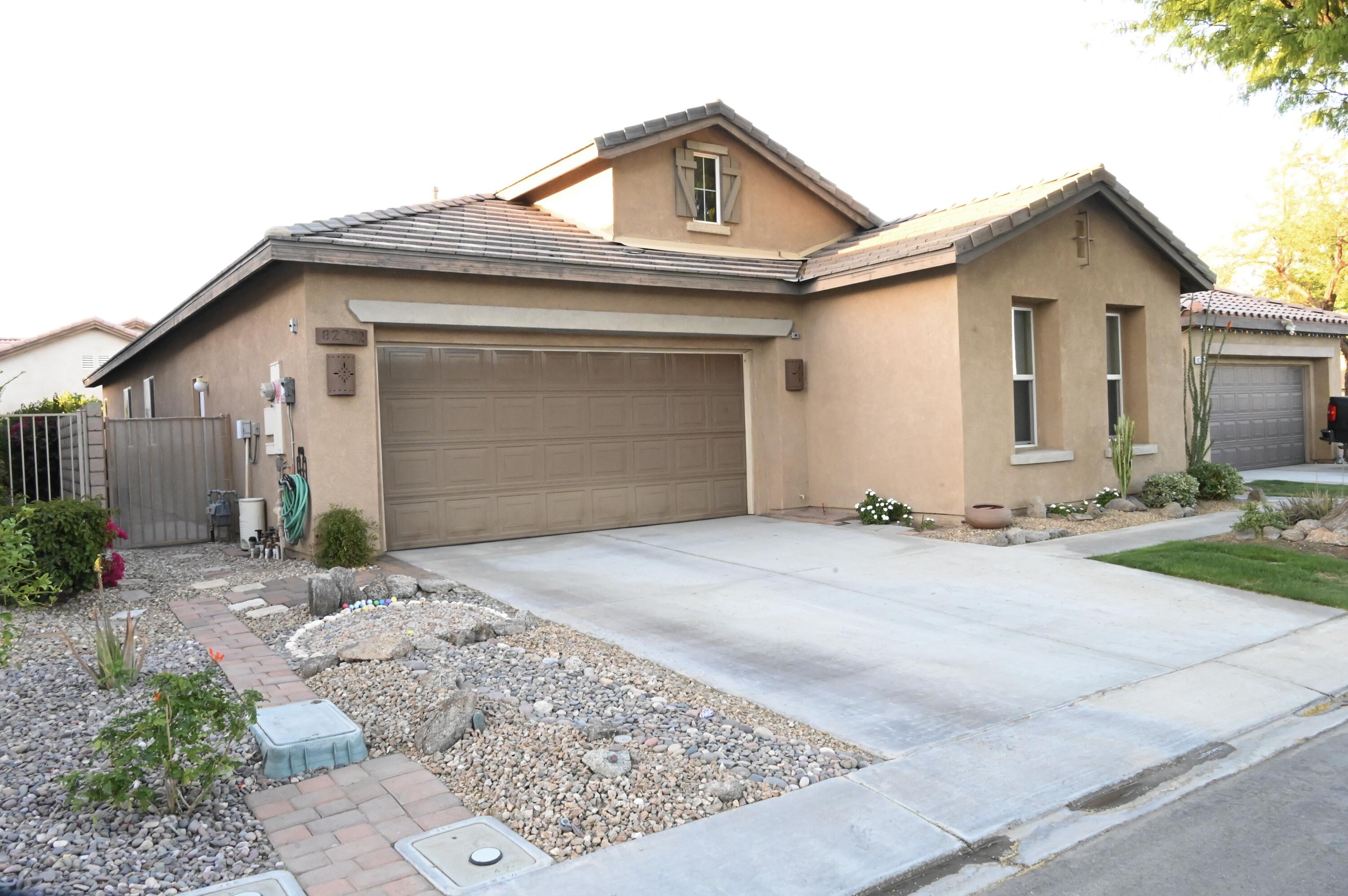 82782 Matthau Drive Indio, CA 92201 - Photo 23 of 27 a front view of a house with a yard and garage