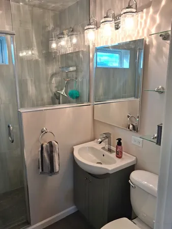 a bathroom with a sink and mirror with toilet