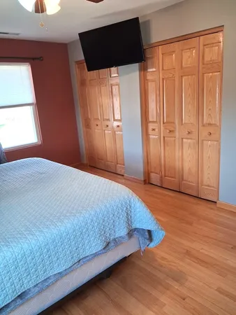 a bedroom with a bed and wooden floor