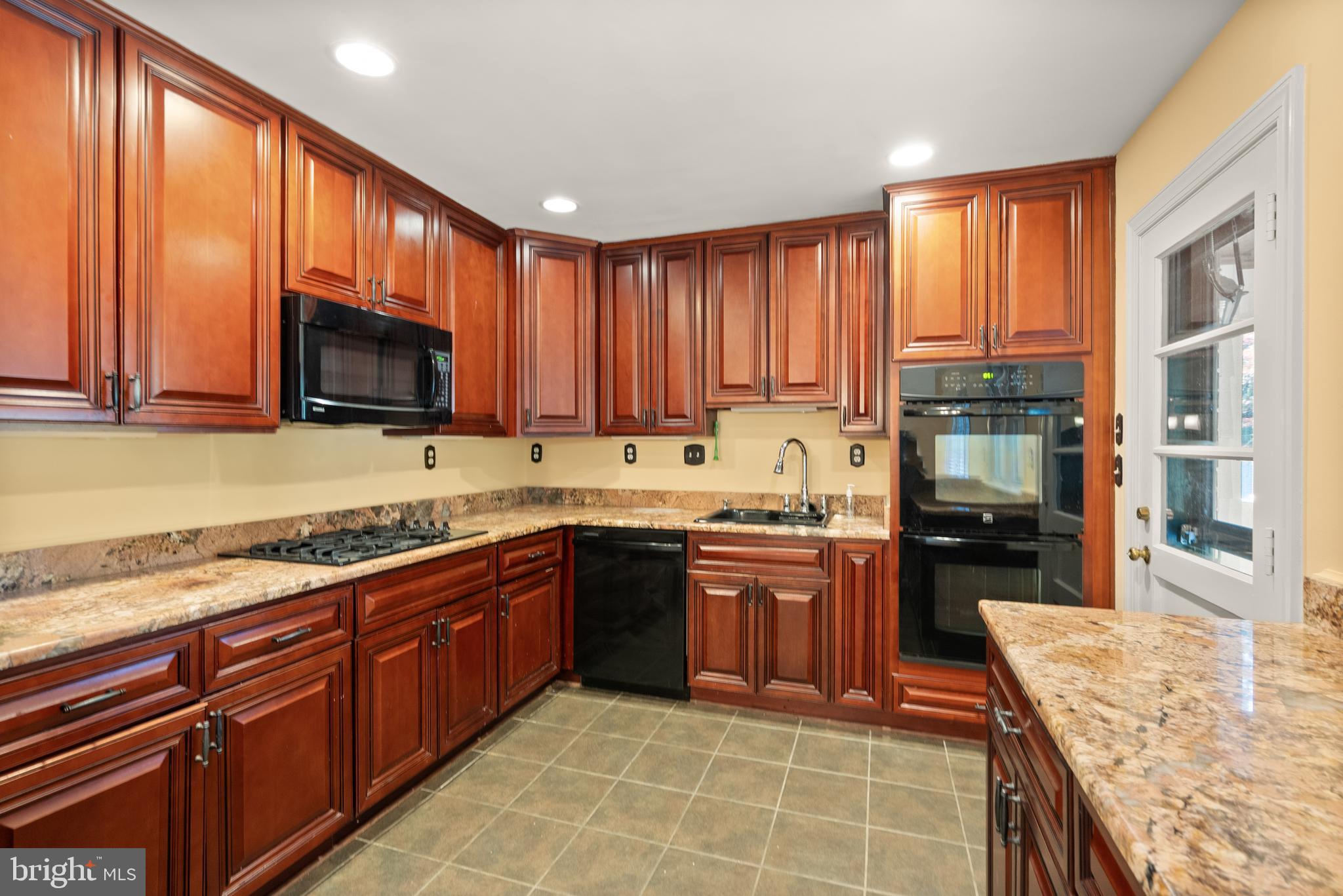 1726 Baldwin Drive McLean, VA 22101 - Photo 13 of 47 a large kitchen with stainless steel appliances granite countertop wooden cabinets a stove top oven a granite counter space and a window