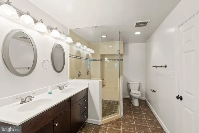 a spacious bathroom with a double vanity sink mirror and toilet