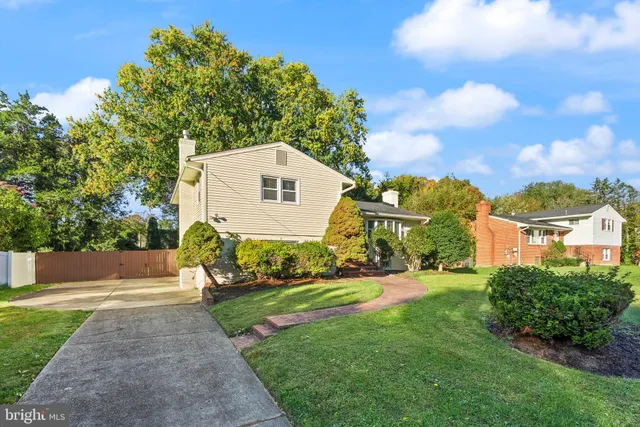 a front view of a house with a yard and trees