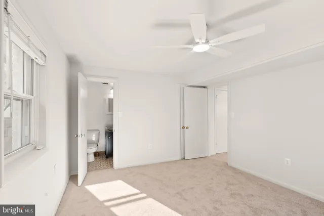 a view of a room with a stylish ceiling fan and entryway