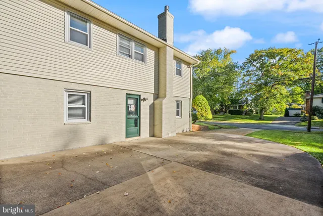 a front view of a house with a yard and trees