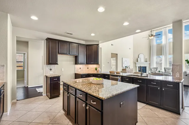 a kitchen with stainless steel appliances granite countertop wooden cabinets a stove top oven a sink and dishwasher
