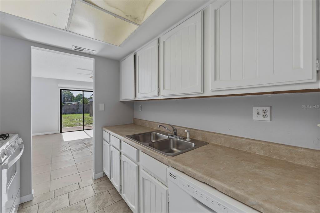 4799 Sisson Road Titusville, FL 32780 - Photo 9 of 23 a kitchen with granite countertop white cabinets and sink