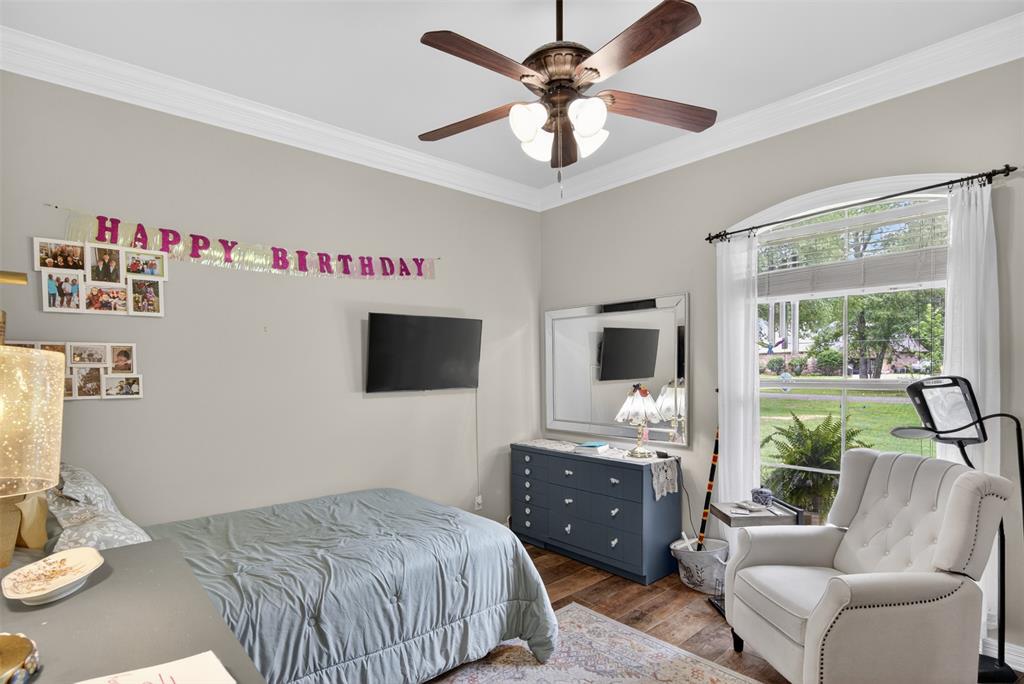 11868 Timber Ridge Drive Keithville, LA 71047 - Photo 18 of 37 Bedroom featuring a wood-finish floor and a large arched window with white curtains