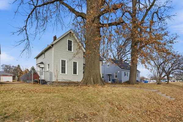 a view of wooden house with large trees