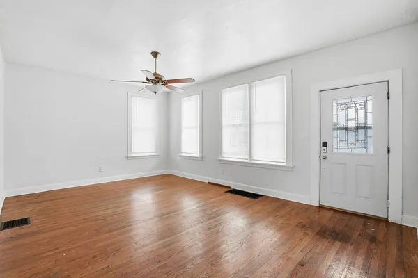 a view of a room with wooden floor and a window