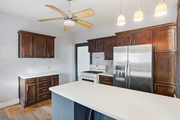 a kitchen with cabinets stainless steel appliances and wooden floor