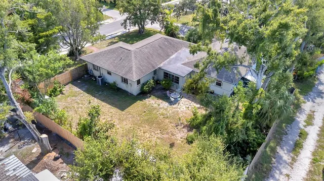 an aerial view of a house with a yard large trees and plants
