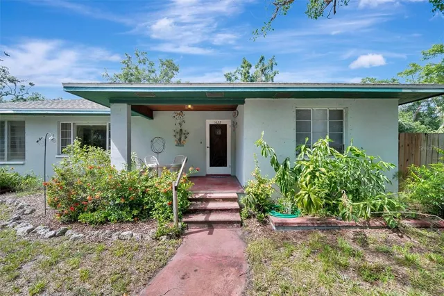 a view of a balcony with chair and potted plants