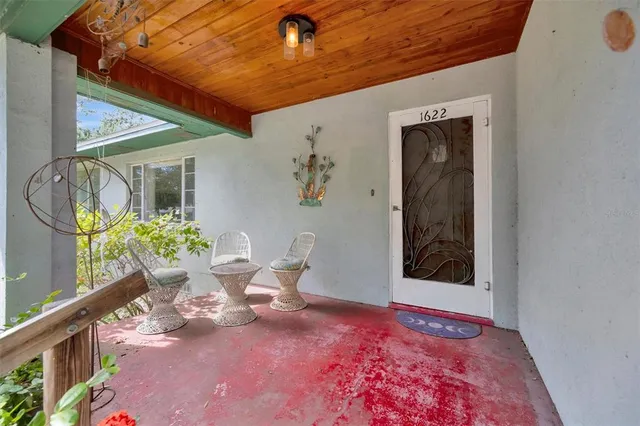 a backyard with table and chairs with potted plants