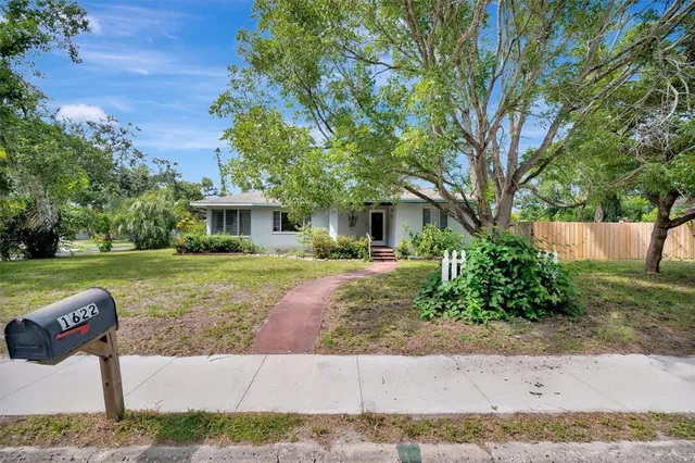 an aerial view of residential house with yard and mountain view in back