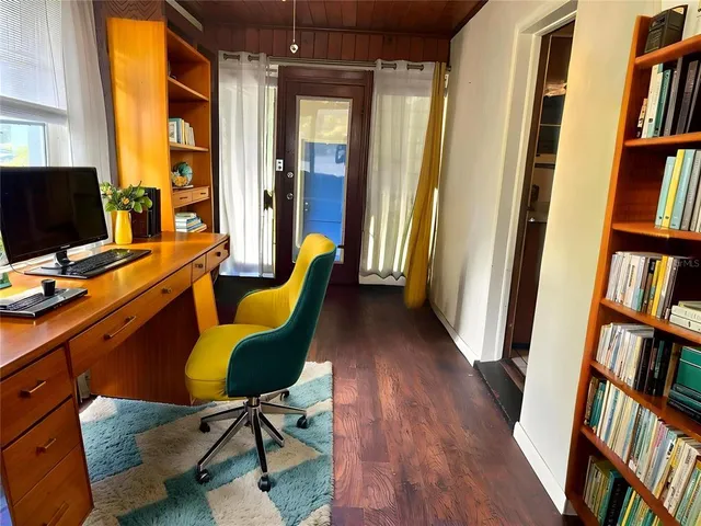 a view of a workspace with furniture and a bookshelf