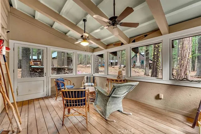 a view of a balcony with wooden floor and cabinet
