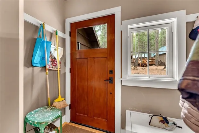 a backyard of a house with wooden floor chairs and a large tree
