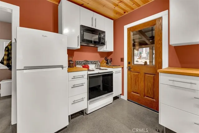 a kitchen with stainless steel appliances white cabinets and a refrigerator