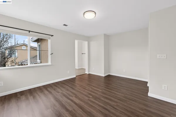 a view of an empty room with wooden floor