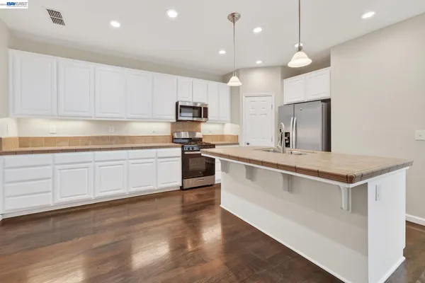 a kitchen with a sink a counter top space and a ceiling fan