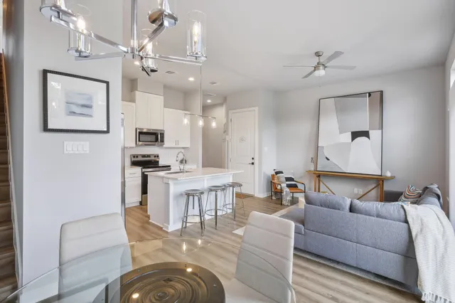 a living room with furniture kitchen and a chandelier