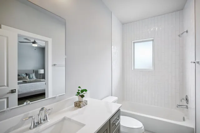 a bathroom with a granite countertop sink a toilet and shower