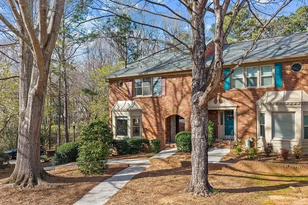 a view of a white house with a large tree
