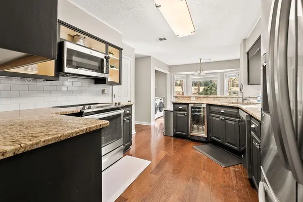 a kitchen with stainless steel appliances granite countertop a stove a sink and a microwave