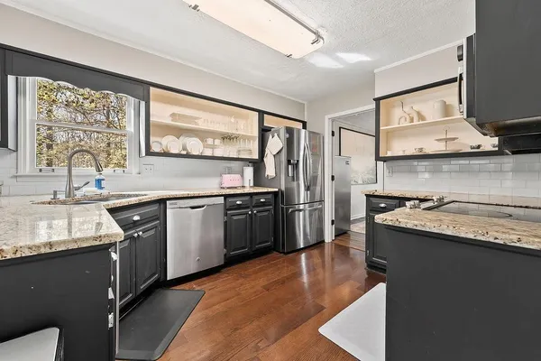 a kitchen with stainless steel appliances granite countertop a sink stove and refrigerator