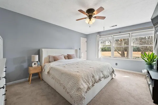 a bedroom with a large bed and a chandelier
