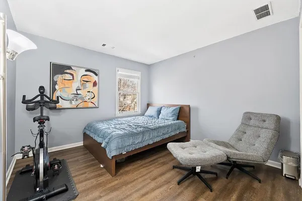 a bedroom with a bed and wooden floor