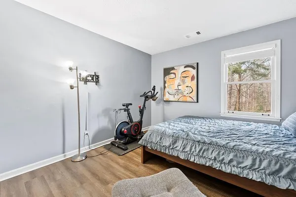 a bedroom with a bed and wooden floor