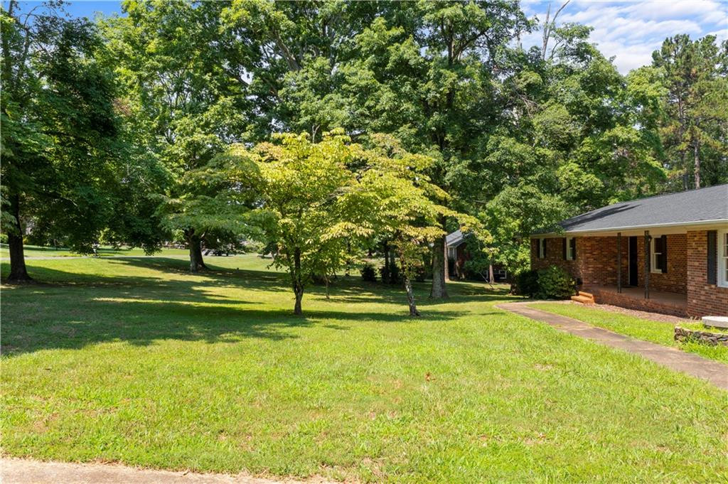 137 Roxdale Place Roxboro, NC 27574 - Photo 4 of 30 a view of a house with a big yard and large trees