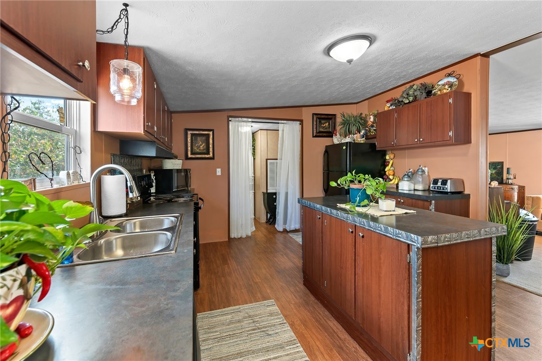 14815 Johnson Rd Trail Manor, TX 78653 - Photo 21 of 37 a kitchen with stainless steel appliances granite countertop sink stove and wooden cabinets