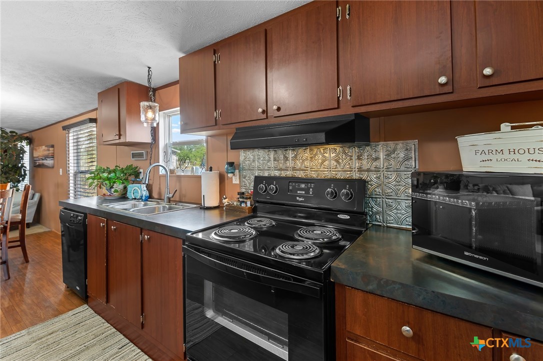 14815 Johnson Rd Trail Manor, TX 78653 - Photo 22 of 37 a kitchen with stainless steel appliances granite countertop a stove and a microwave