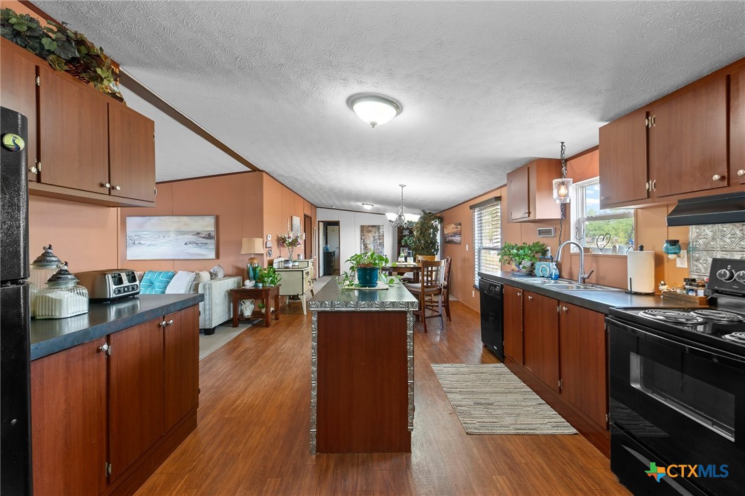 14815 Johnson Rd Trail Manor, TX 78653 - Photo 23 of 37 a kitchen with lots of counter top space and wooden floor