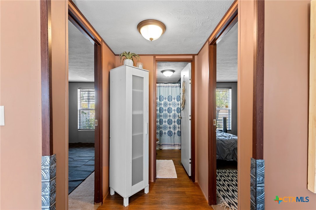 14815 Johnson Rd Trail Manor, TX 78653 - Photo 30 of 37 a view of a hallway with bathroom and wooden floor