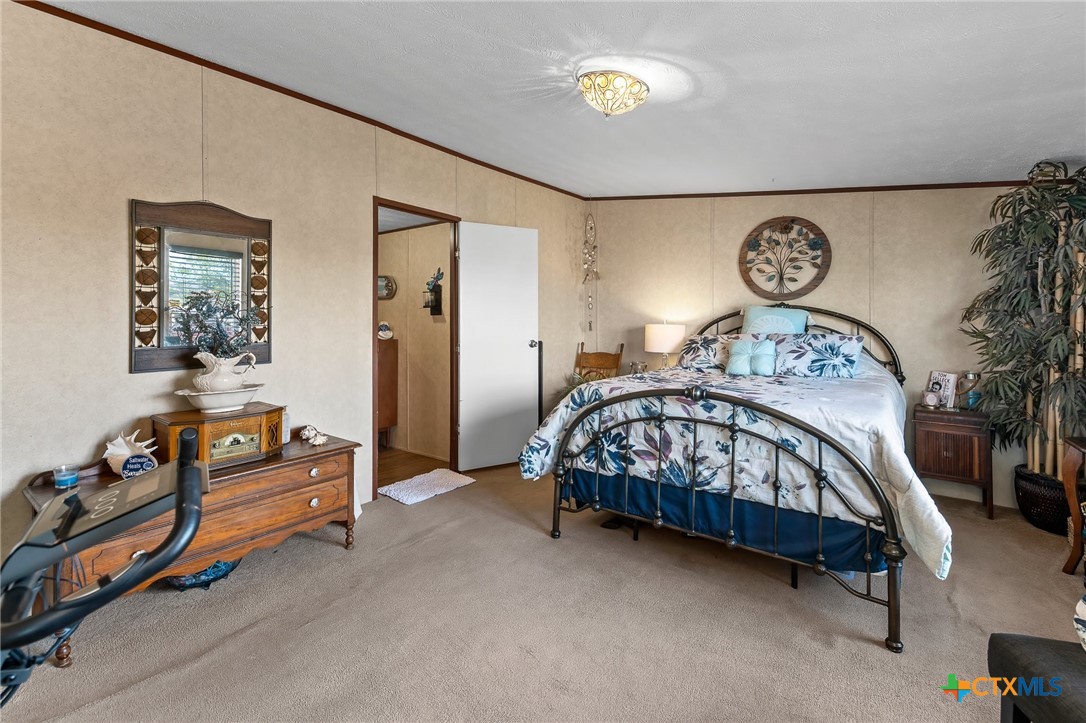 14815 Johnson Rd Trail Manor, TX 78653 - Photo 31 of 37 a bedroom with a bed and a lamp on a dresser